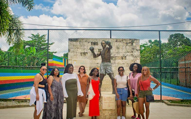 Tour group at Antonio Cervantes statue in San Basilio de Palenque.
