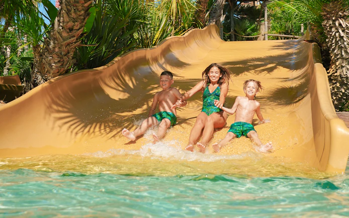 Tourists sliding down a water slide at Caribe Bay.