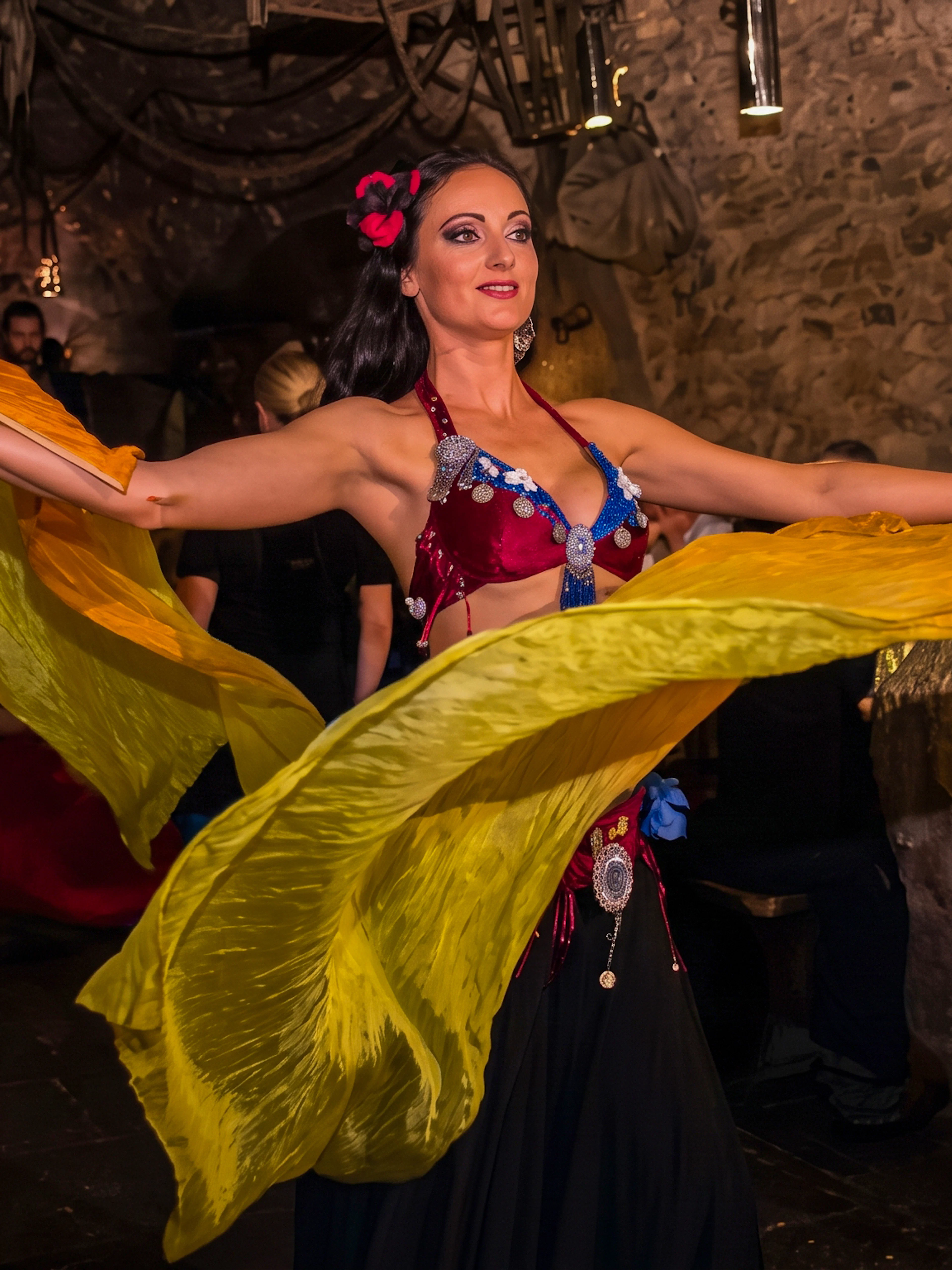 Dancer performing at a medieval dinner show in Prague with colorful fabric.