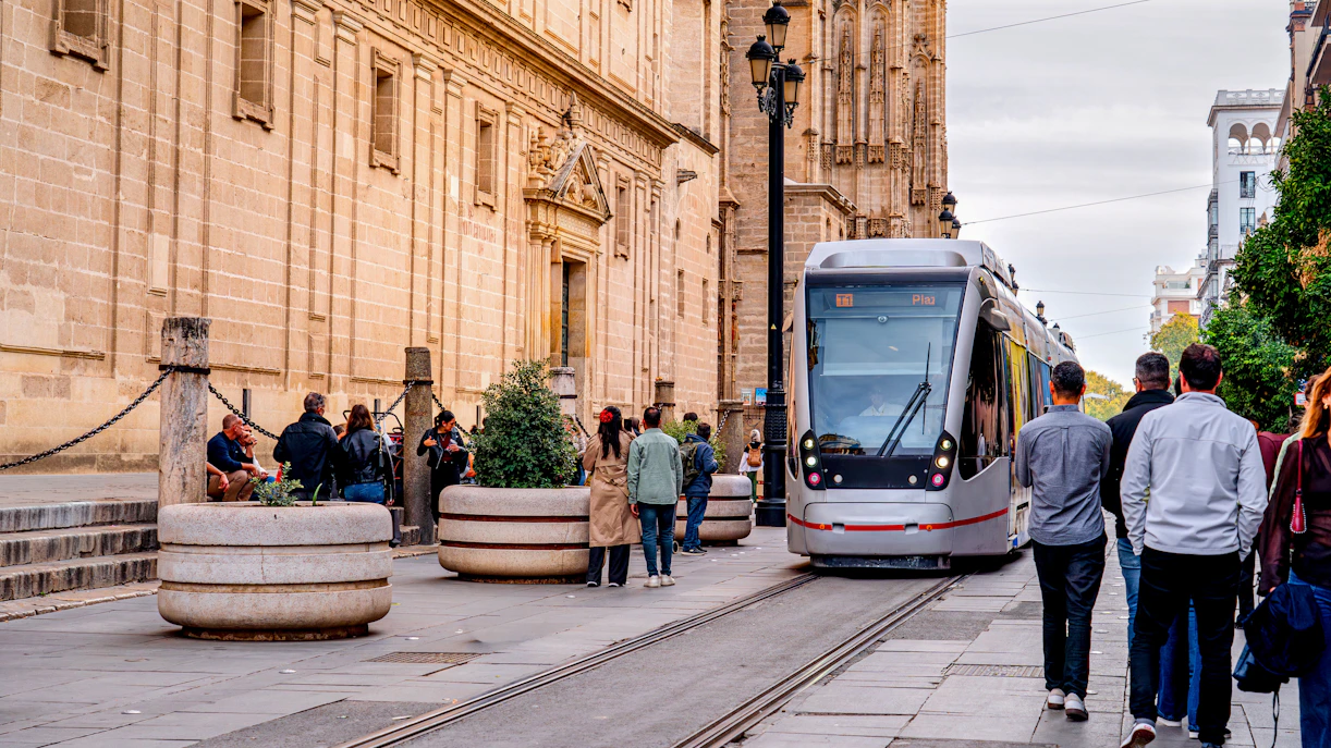 Tram passing by historic buildings in Seville, Spain.