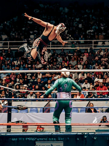 Wrestler leaping in Lucha Libre match at Arena Mexico, Mexico City.