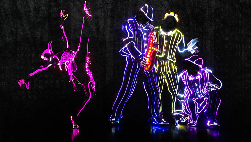 Dancers in neon light suits performing at iLuminate show.