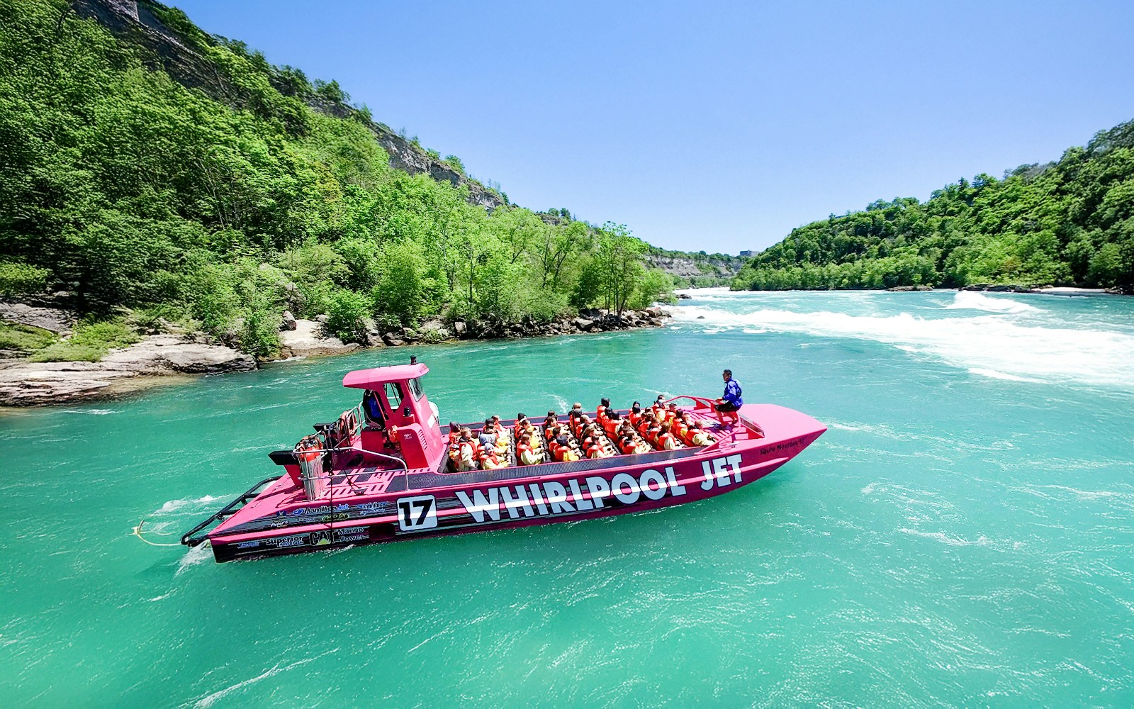 People taking a selfie on a boat with Niagara Falls in the background, Ontario, Canada.