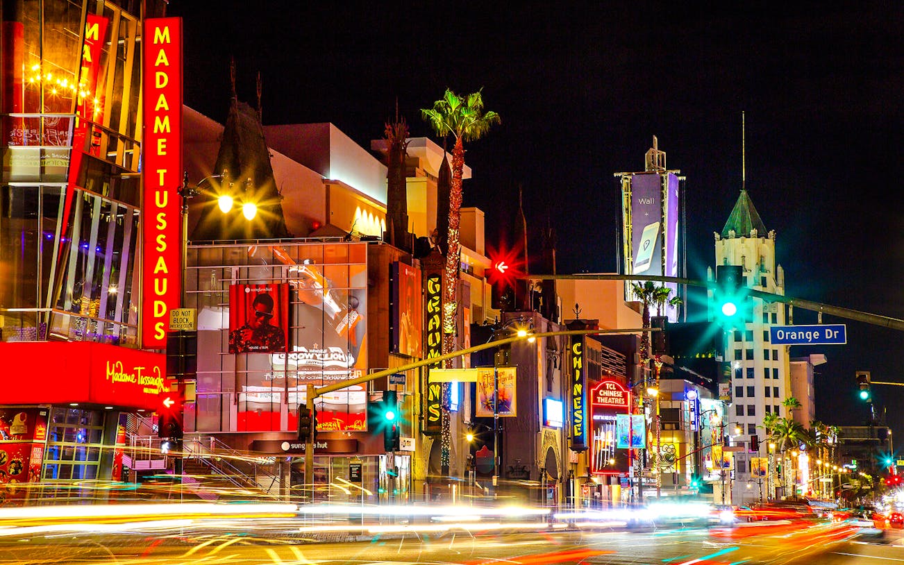 Madame Tussauds Hollywood entrance at night with neon lights on Hollywood Boulevard.