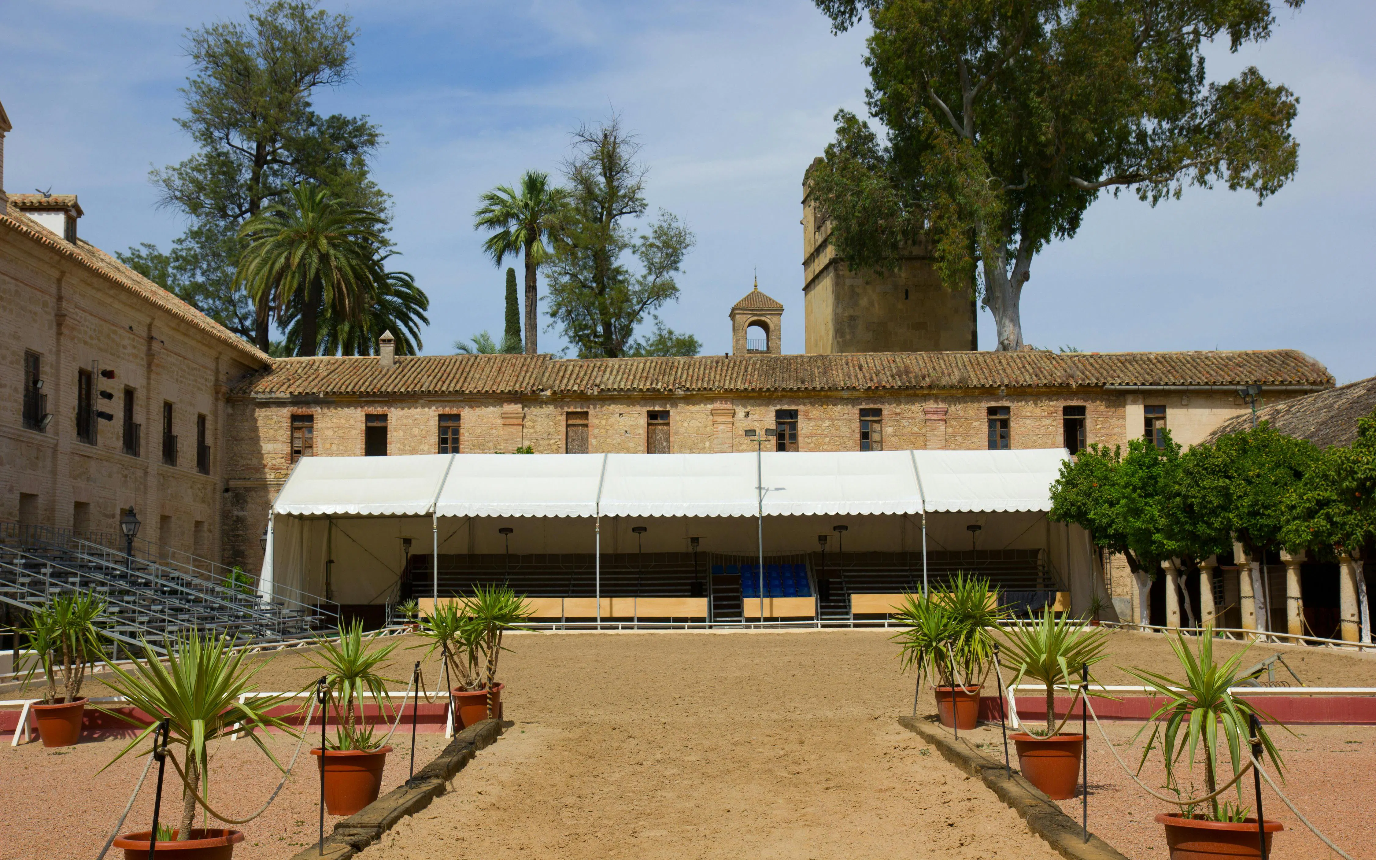 Caballerizas Reales courtyard with seating and palm trees, Cordoba, Spain.