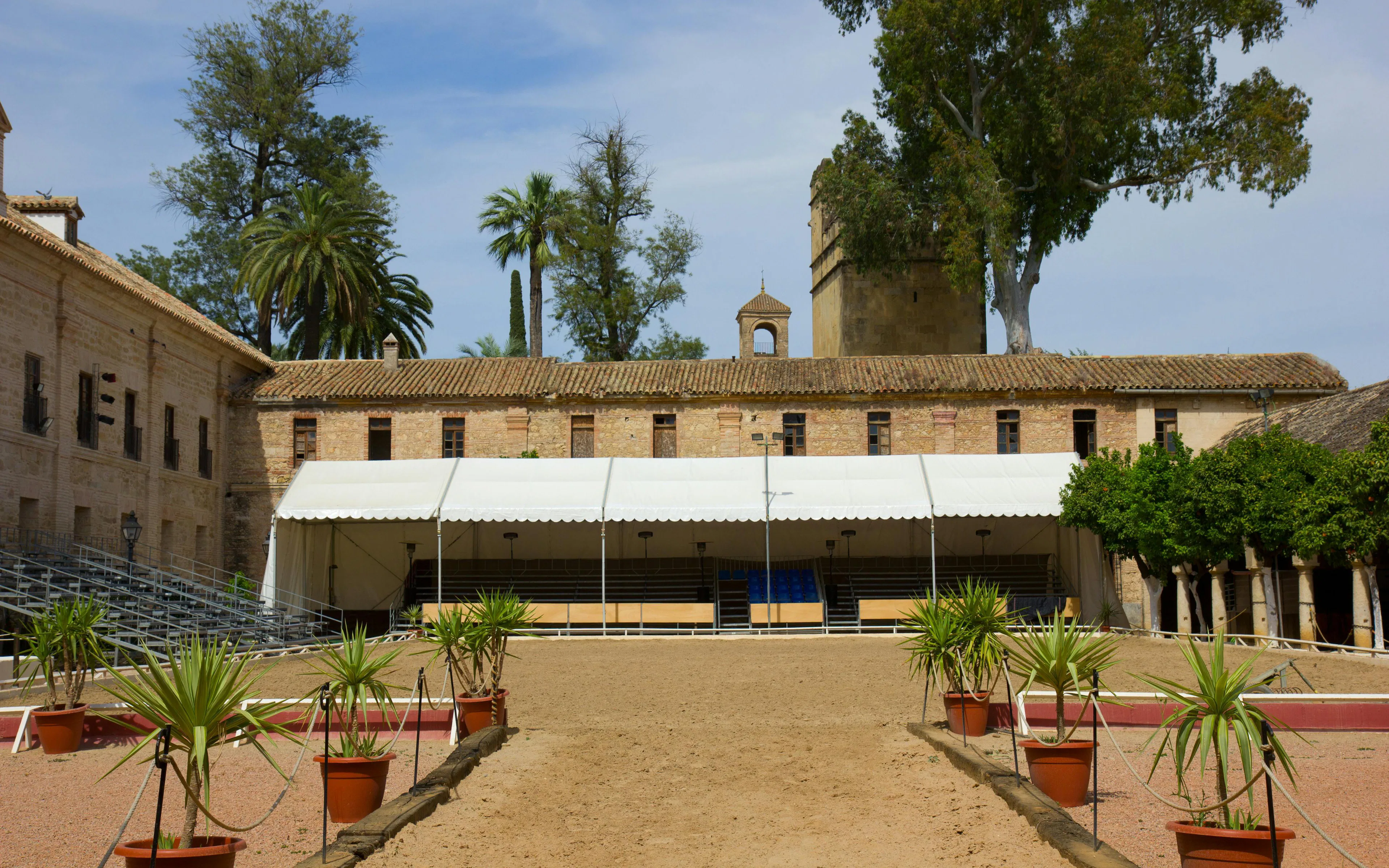 Caballerizas Reales courtyard with seating and palm trees, Cordoba, Spain.
