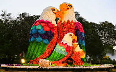 Floral eagle sculptures at Dubai Garden Glow with Dubai Frame in the background.