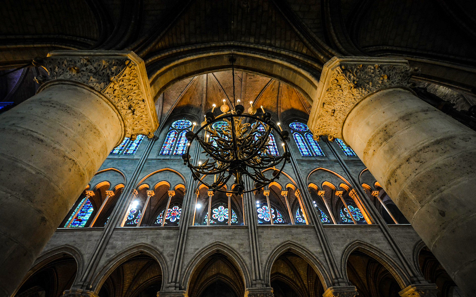 Sainte Chapelle interior with stained glass windows and ornate chandelier.