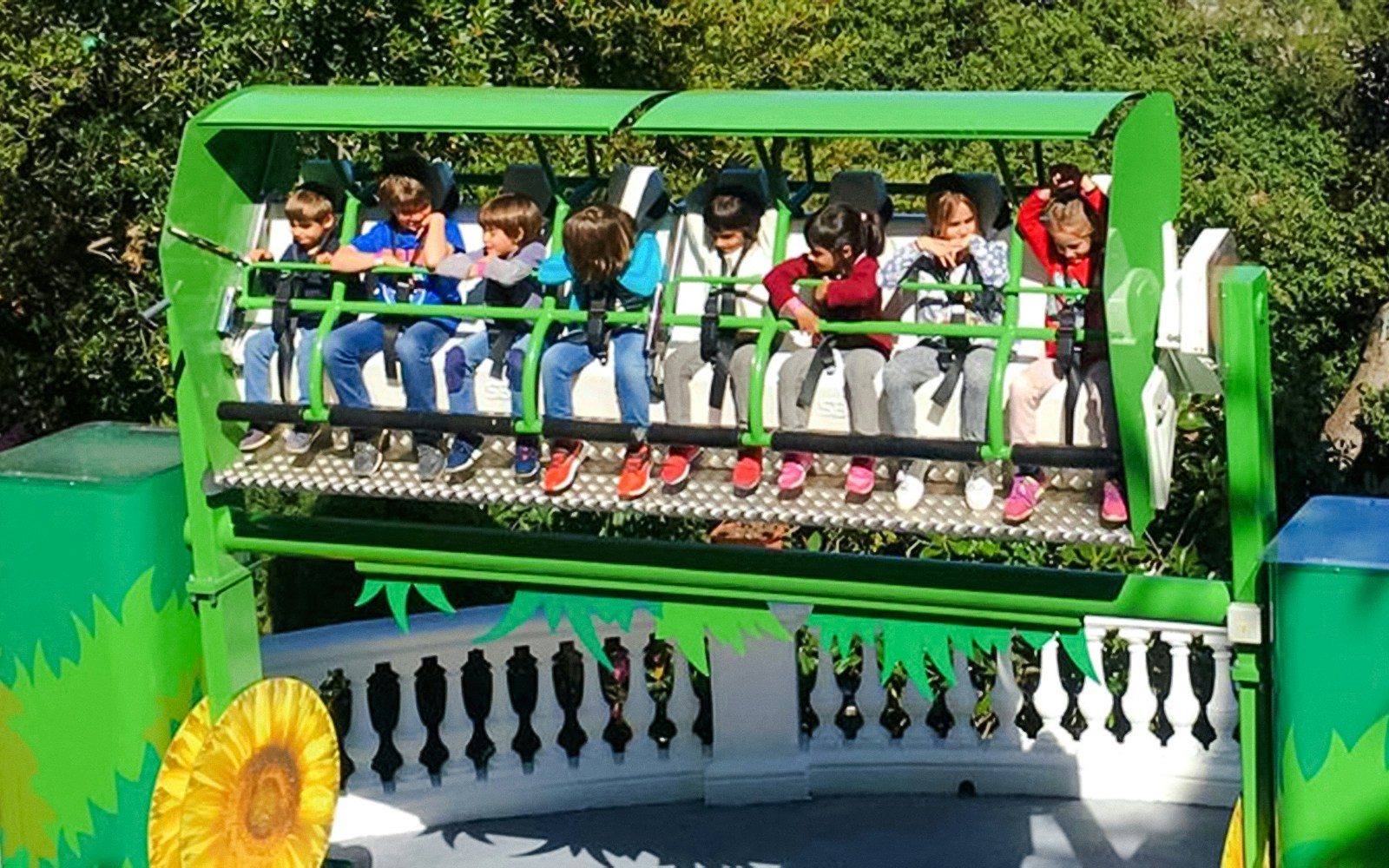 Children enjoying the Mini Hurakan ride at an amusement park.