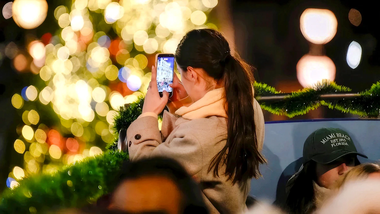 Person taking a photo of Christmas lights in London.