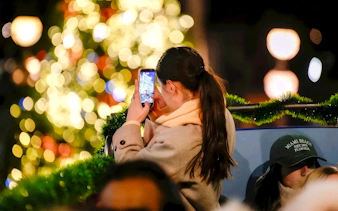 Person taking a photo of Christmas lights in London.