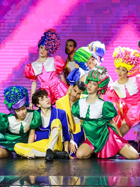 Performers in colorful costumes on stage during Paris: My First Cabaret show.