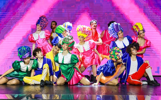 Performers in colorful costumes on stage during Paris: My First Cabaret show.