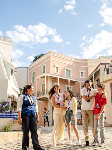 Group enjoying a guided tour at Universal Studios Hollywood with colorful buildings in the background.