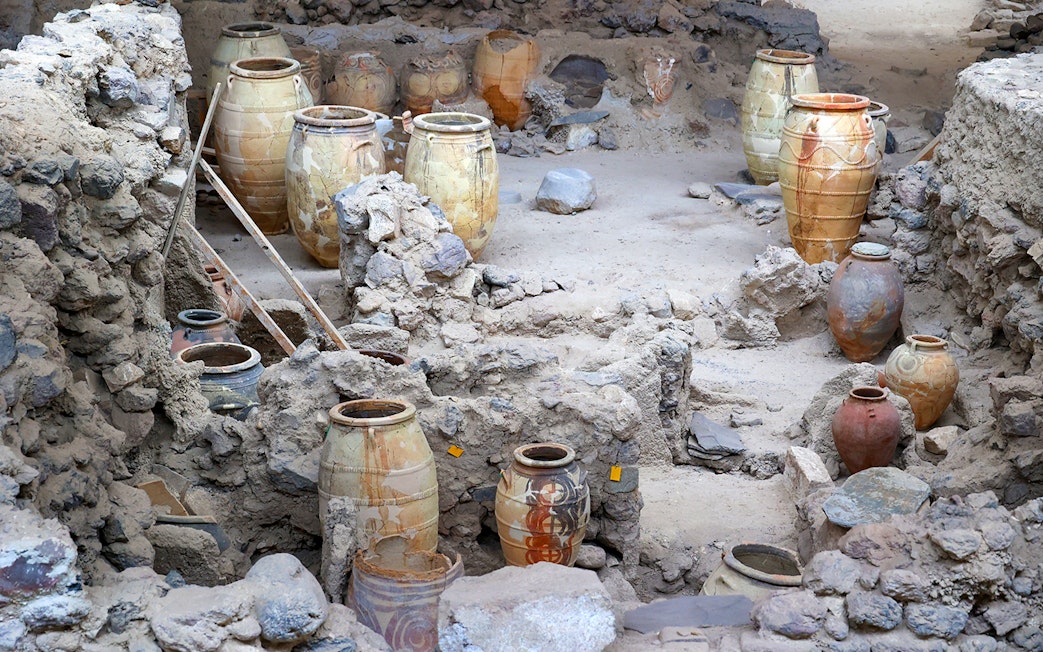 Amphorae among ancient ruins at Akrotiri Archaeological Site, Santorini, Greece.