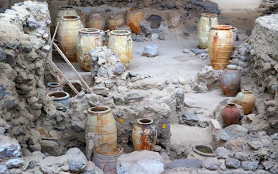 Amphorae among ancient ruins at Akrotiri Archaeological Site, Santorini, Greece.