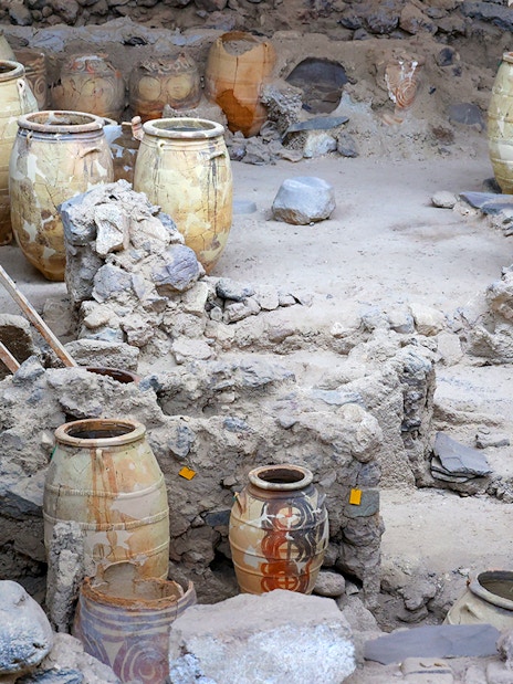Amphorae among ancient ruins at Akrotiri Archaeological Site, Santorini, Greece.