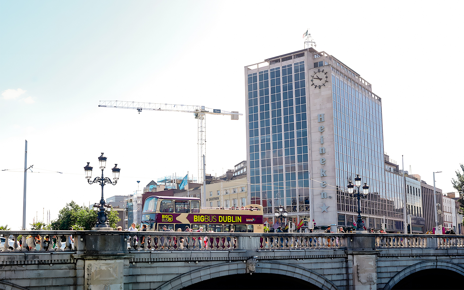 Big Bus Dublin crossing bridge with Heineken building in background.