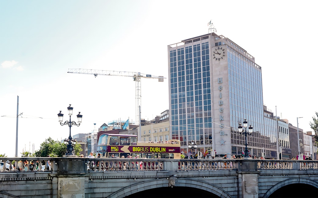 Big Bus Dublin crossing bridge with Heineken building in background.