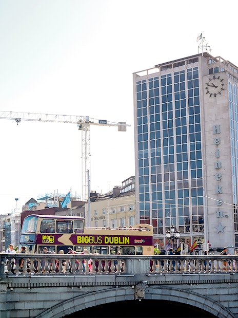 Big Bus Dublin crossing bridge with Heineken building in background.