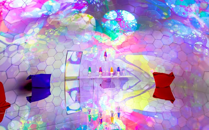 Colorful bubble-themed room with hexagonal patterns and lava lamps at Bubble Planet, Seattle.