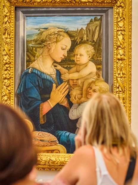Visitors viewing a Botticelli painting in the Uffizi Gallery, Florence.