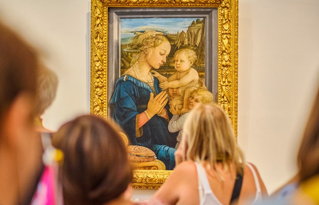Visitors viewing a Botticelli painting in the Uffizi Gallery, Florence.