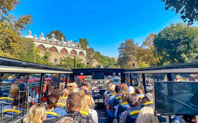 Open-top bus tour with passengers viewing Istanbul's historic architecture along the Bosphorus.