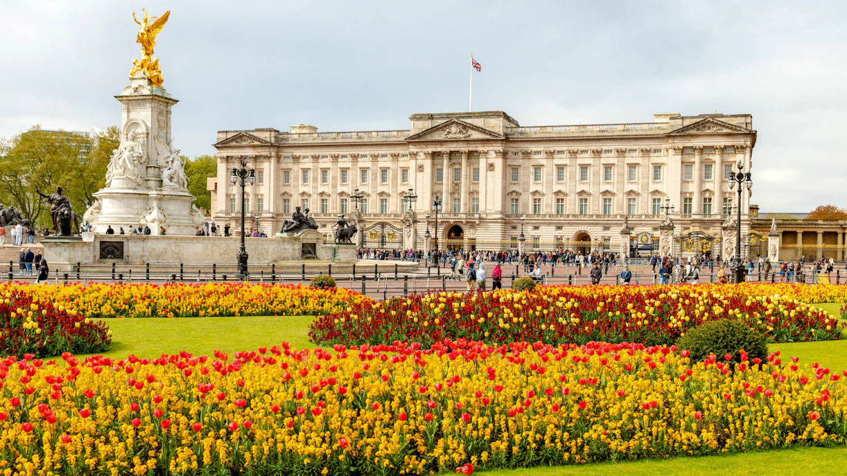 Buckingham Palace with Victoria Memorial and colorful flower gardens in London.