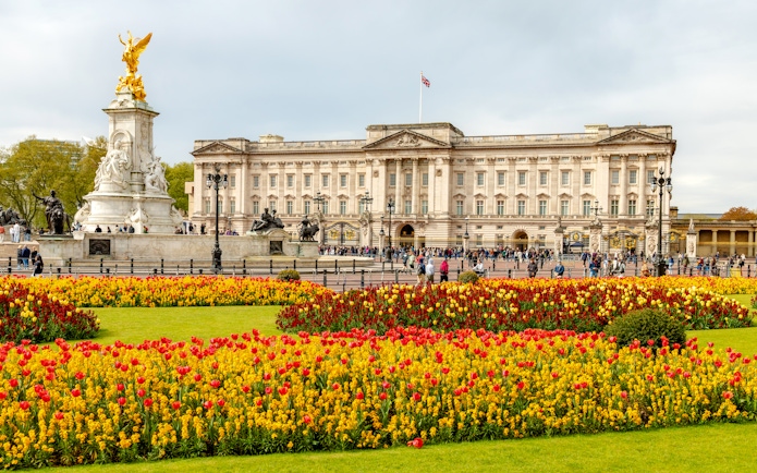 Buckingham Palace with Victoria Memorial and colorful flower gardens in London.