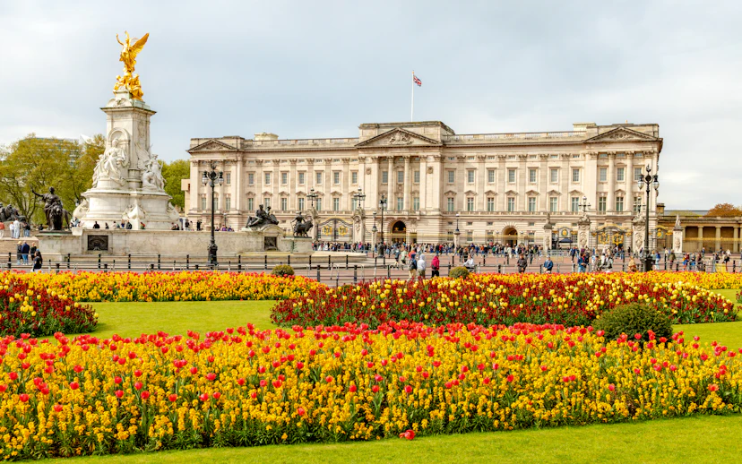 Buckingham Palace with Victoria Memorial and colorful flower gardens in London.