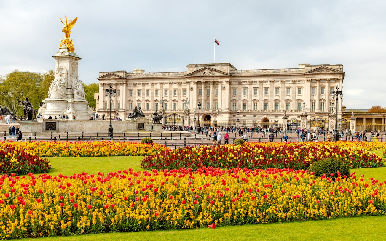 Buckingham Palace with Victoria Memorial and colorful flower gardens in London.