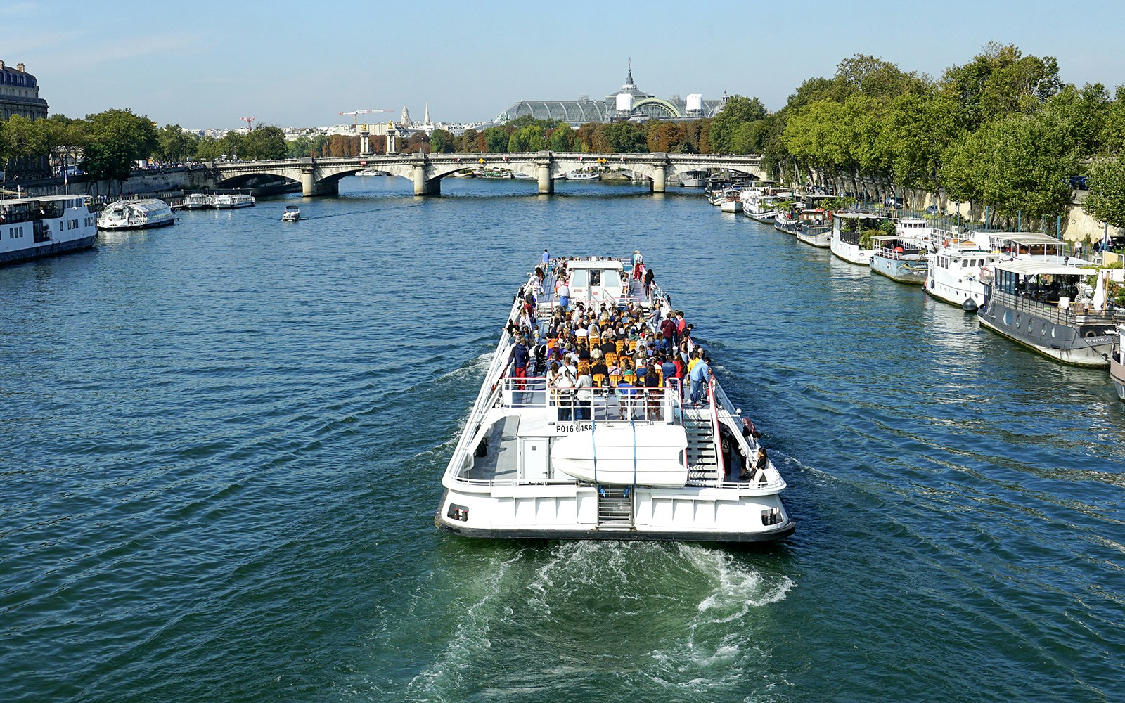 Tourists enjoying a 2.5-hour Seine River and Canal St Martin sightseeing cruise in Paris, with a view of iconic landmarks