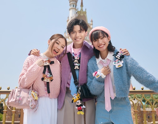 Visitors enjoying Disneyland Hong Kong with castle in background.