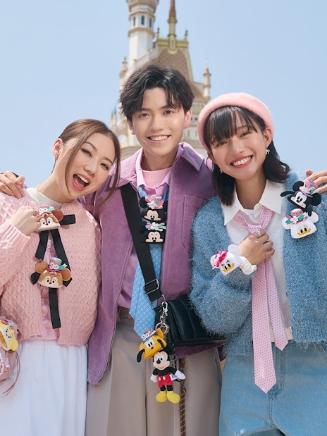 Visitors enjoying Disneyland Hong Kong with castle in background.