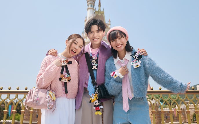 Visitors enjoying Disneyland Hong Kong with castle in background.