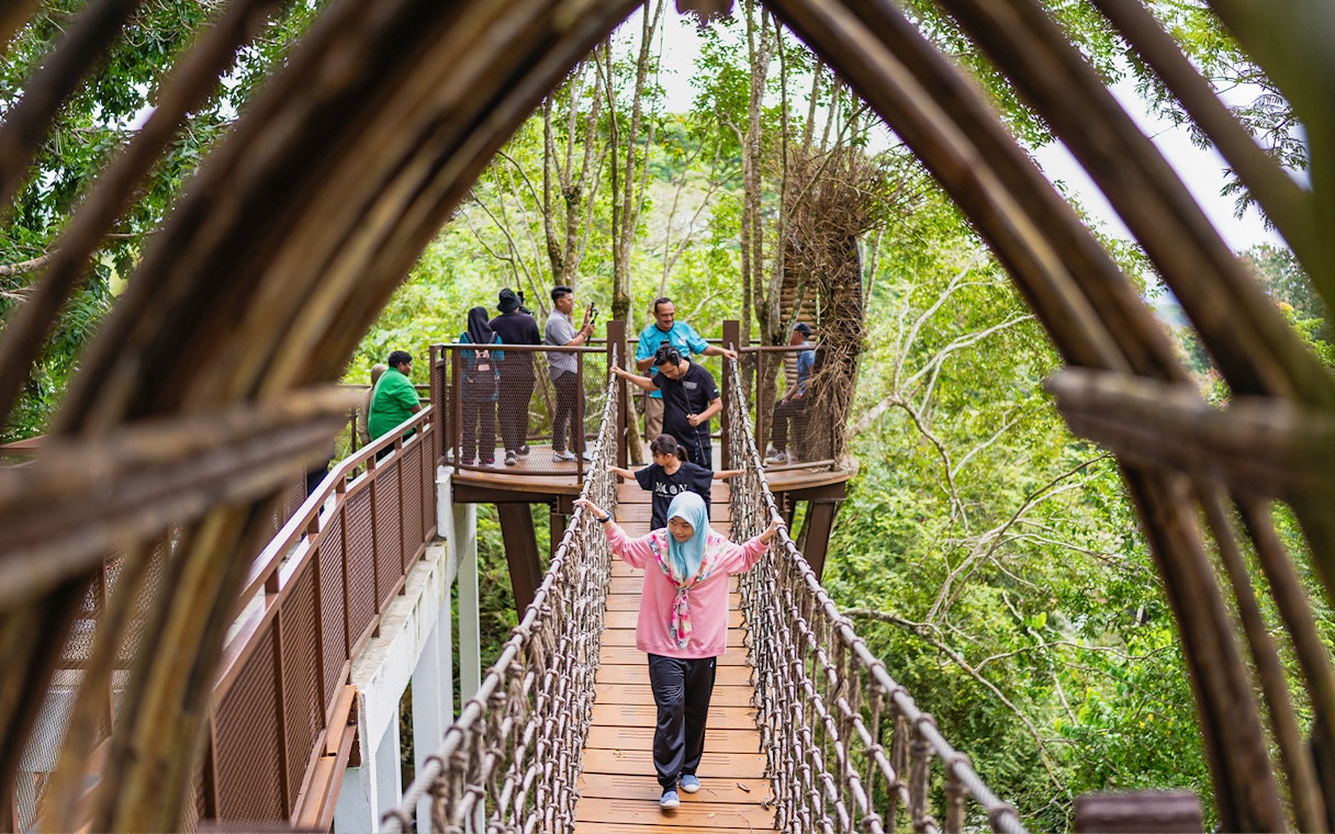Visitors crossing a canopy bridge at Crocodile Adventureland Langkawi.