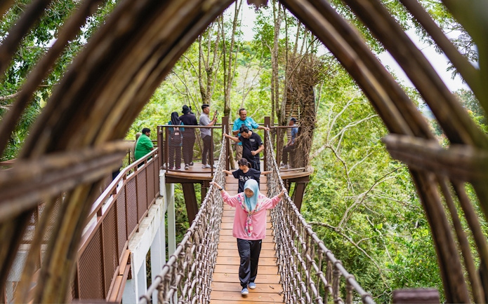 Visitors crossing a canopy bridge at Crocodile Adventureland Langkawi.
