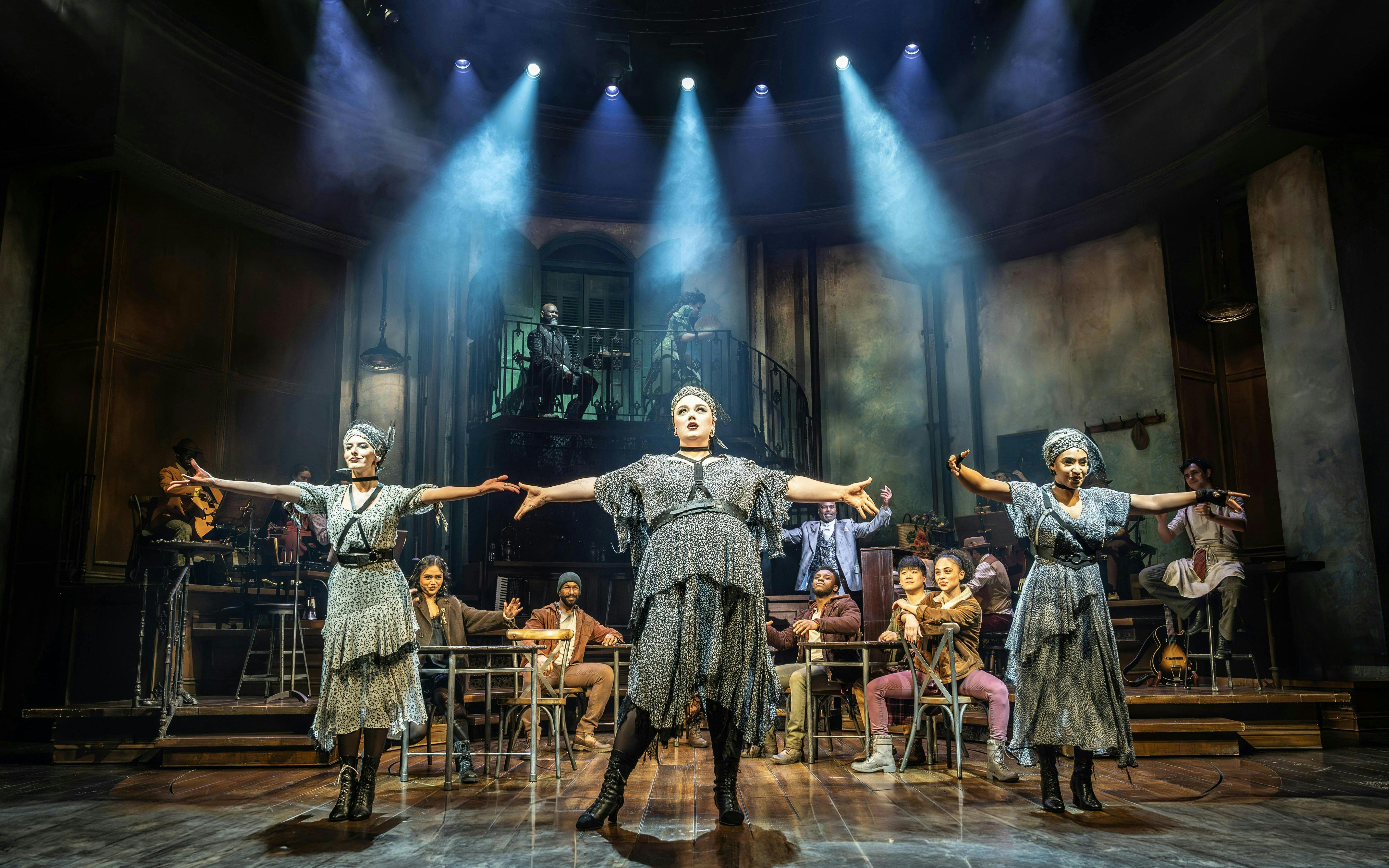 Stage performance of Hadestown in West End with actors in dramatic pose.