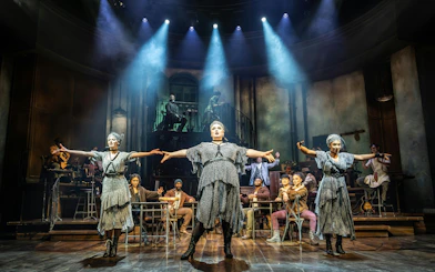 Stage performance of Hadestown in West End with actors in dramatic pose.