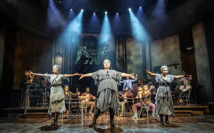 Stage performance of Hadestown in West End with actors in dramatic pose.