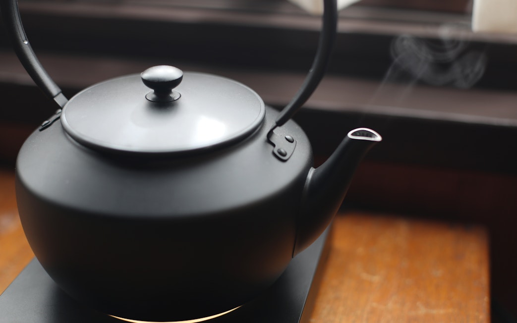 Electric kettle with steam rising, used for making tea.