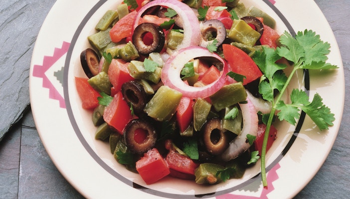 Mexican salad with fresh vegetables and avocado slices in a bowl.