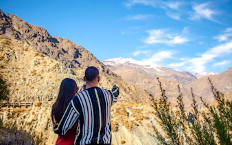 Couple admiring Andes mountains near Portillo, Santiago.