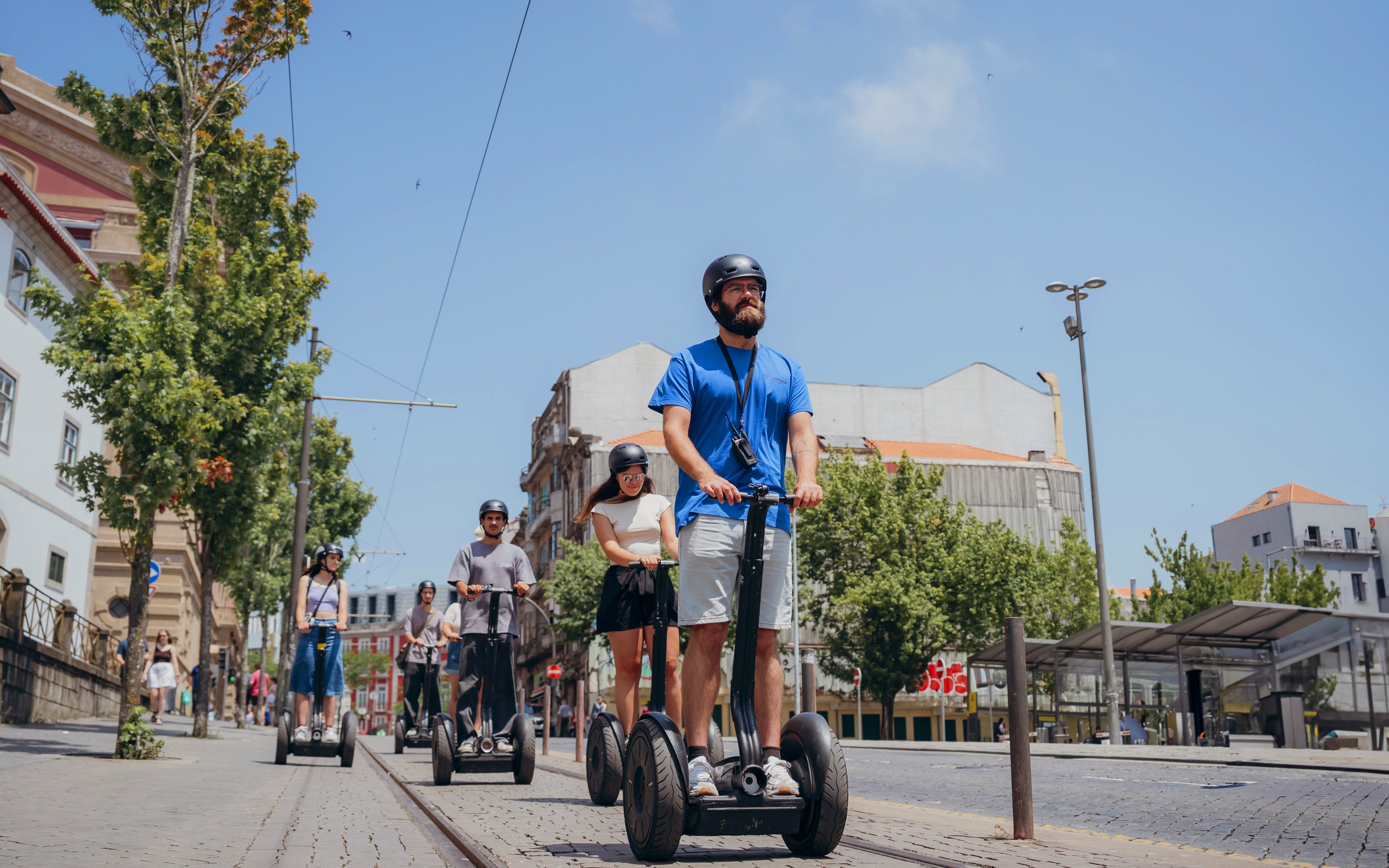Tourists on Segway tour exploring Porto's city highlights with a guide.
