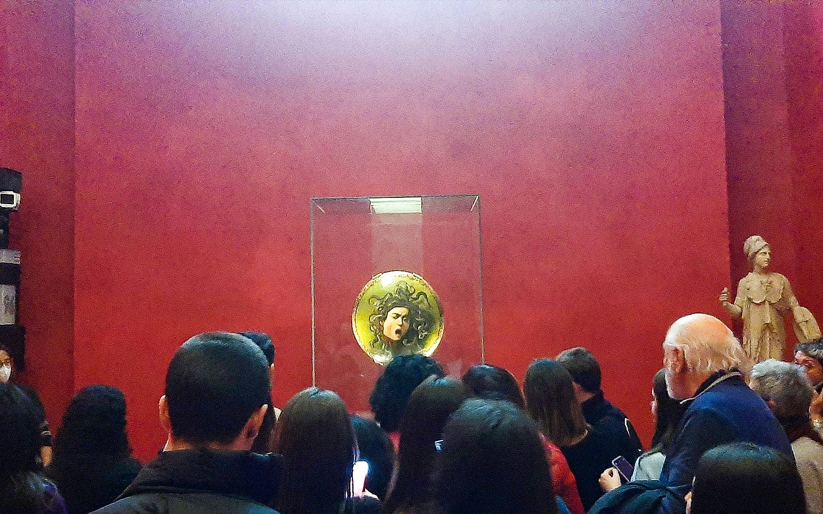 Visitors exploring art at Uffizi & Accademia Galleries, Florence, with audio guide.