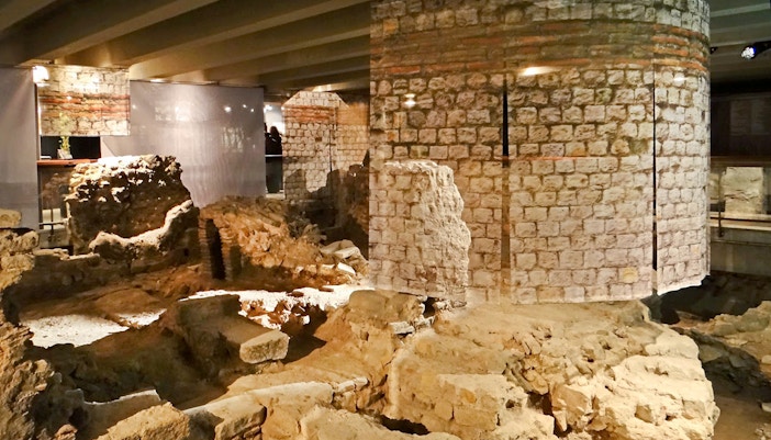 Notre Dame archaeological crypt entrance in Paris with historical artifacts displayed.