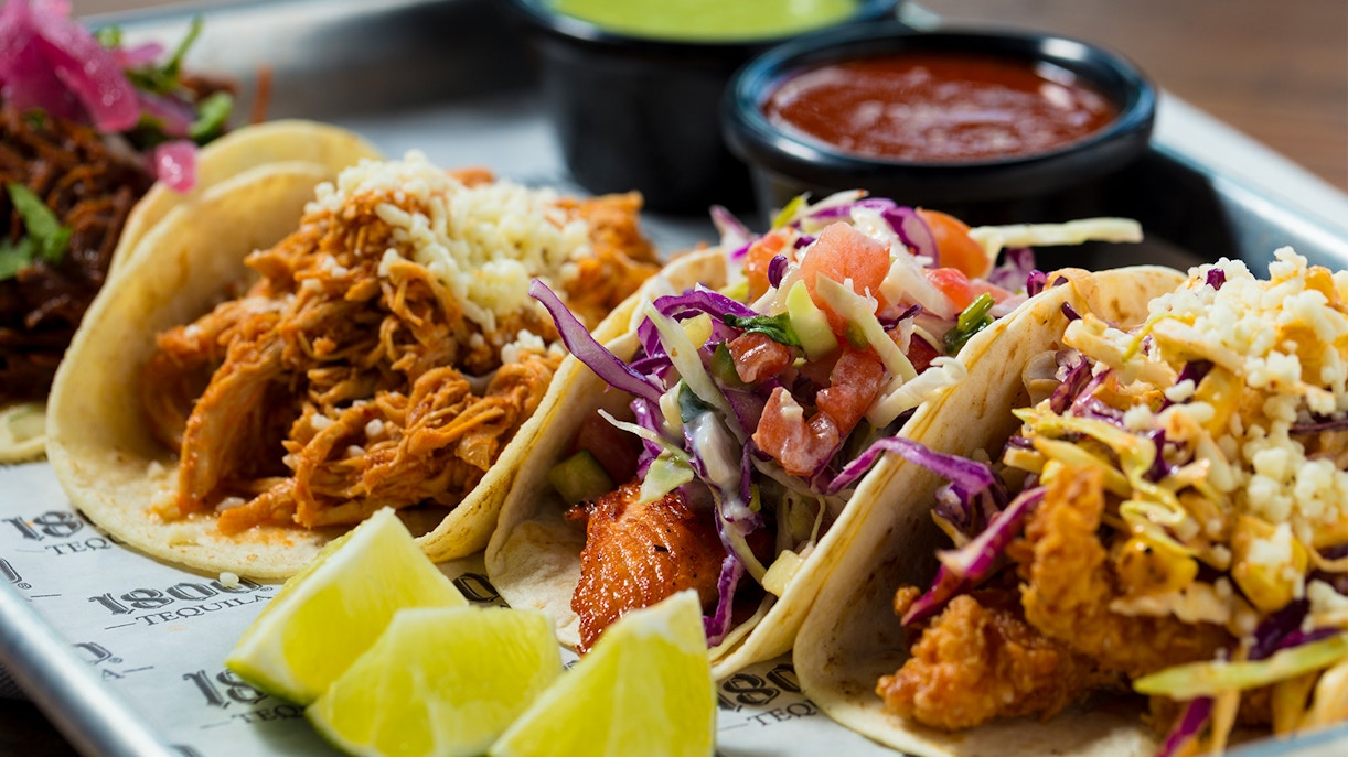 Handmade tacos with fresh ingredients displayed on a wooden board