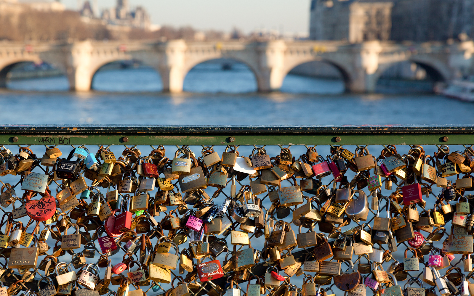 Love locks on Pont des Arts bridge with Seine River view in Paris.
