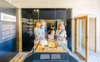 Family viewing a model exhibit at the Chateau of Chantilly museum.